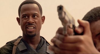 Movie still from “Bad Boys” (1995), directed by Michael Bay – A person holding a gun; Close Up shot, Low angle