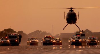 Movie still from “Bad Boys” (1995), directed by Michael Bay – A group of police cars driving down a street; Extreme Wide shot, Low angle