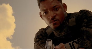 Movie still from “Bad Boys” (1995), directed by Michael Bay – A man holding a gun while wearing a black shirt; Close Up shot, Low angle