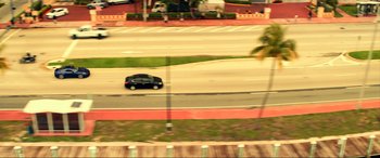 Movie still from “Bad Boys for Life” (2020), directed by Adil El Arbi – A car driving down a street past palm trees; Extreme Wide shot, High angle