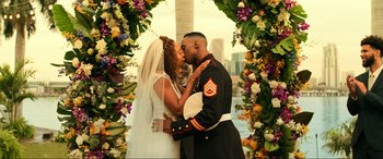 Movie still from “Bad Boys for Life” (2020), directed by Adil El Arbi – A military man and woman kissing in front of a floral archway; Medium shot, Low angle
