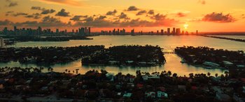 Movie still from “Bad Boys for Life” (2020), directed by Adil El Arbi – An aerial view of a body of water and a city skyline at sunset; Extreme Wide shot, High angle