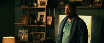 Movie still from “Bad Boys for Life” (2020), directed by Adil El Arbi – A man standing in front of a book shelf; Close Up shot, Over the shoulder angle