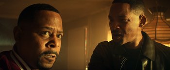 Movie still from “Bad Boys for Life” (2020), directed by Adil El Arbi – Two men in a dimly - lit room , one of whom is looking at the camera; Close Up shot, Over the shoulder angle