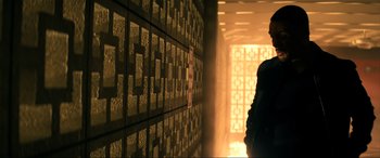 Movie still from “Bad Boys for Life” (2020), directed by Adil El Arbi – A person standing in a room with a wall of blocks; Wide shot, Low angle