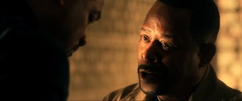 Movie still from “Bad Boys for Life” (2020), directed by Adil El Arbi – A man is looking at another man in a dimly - lit room; Close Up shot, Over the shoulder angle