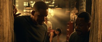 Movie still from “Bad Boys for Life” (2020), directed by Adil El Arbi – A man and a woman in a dark room; Medium shot, Over the shoulder angle