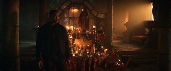 Movie still from “Bad Boys for Life” (2020), directed by Adil El Arbi – A man standing in front of a table filled with lit candles; Wide shot, High angle