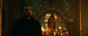 Movie still from “Bad Boys for Life” (2020), directed by Adil El Arbi – A man standing in front of candles in front of a statue; Medium shot, Low angle