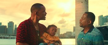 Movie still from “Bad Boys for Life” (2020), directed by Adil El Arbi – A man and a child looking at each other in front of a city skyline; Medium shot, Low angle