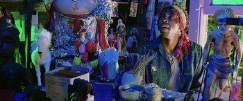 Movie still from “Bad Boys II” (2003), directed by Michael Bay – A man standing in front of a table filled with vases and figurines; Medium shot, Low angle