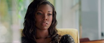 Movie still from “Bad Boys II” (2003), directed by Michael Bay – A beautiful young woman sitting on a couch; Close Up shot, Over the shoulder angle