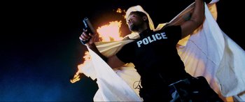 Movie still from “Bad Boys II” (2003), directed by Michael Bay – A man in a police uniform holding a gun; Medium shot, Low angle