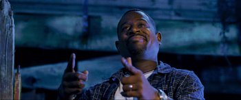 Movie still from “Bad Boys II” (2003), directed by Michael Bay – A man is smiling while holding his hands up; Close Up shot, Low angle