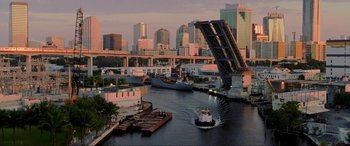 Movie still from “Bad Boys II” (2003), directed by Michael Bay – A boat traveling down a river next to a bridge; Extreme Wide shot, High angle