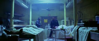 Movie still from “Bad Boys II” (2003), directed by Michael Bay – Two men standing in a room next to a bed; Wide shot, High angle