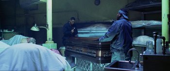Movie still from “Bad Boys II” (2003), directed by Michael Bay – Two men standing next to an empty casket; Wide shot, High angle