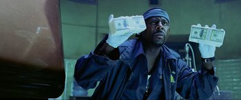 Movie still from “Bad Boys II” (2003), directed by Michael Bay – A man holding a stack of money in his hand; Close Up shot, Low angle