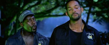 Movie still from “Bad Boys II” (2003), directed by Michael Bay – A man and a man in a black shirt and a tree in the background; Close Up shot, Low angle