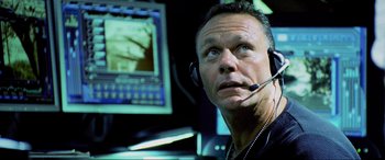 Movie still from “Bad Boys II” (2003), directed by Michael Bay – A man wearing a headset in front of a computer screen; Close Up shot, Low angle