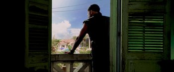 Movie still from “Bad Boys II” (2003), directed by Michael Bay – A man standing on a porch looking out a window; Medium shot, Low angle