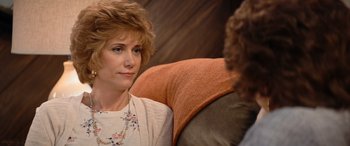 Movie still from “Barb and Star Go to Vista Del Mar” (2021), directed by Josh Greenbaum – A person sitting on a couch; Close Up shot, Over the shoulder angle