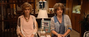 Movie still from “Barb and Star Go to Vista Del Mar” (2021), directed by Josh Greenbaum – A couple of women sitting at a table with wine glasses; Medium shot, High angle