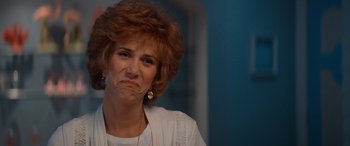 Movie still from “Barb and Star Go to Vista Del Mar” (2021), directed by Josh Greenbaum – A person with her head tilted down; Close Up shot, Over the shoulder angle