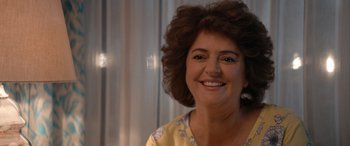 Movie still from “Barb and Star Go to Vista Del Mar” (2021), directed by Josh Greenbaum – A person smiling for the camera; Close Up shot, Over the shoulder angle