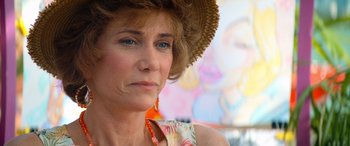Movie still from “Barb and Star Go to Vista Del Mar” (2021), directed by Josh Greenbaum – A person wearing a hat; Close Up shot, Over the shoulder angle