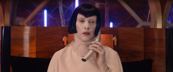 Movie still from “Barb and Star Go to Vista Del Mar” (2021), directed by Josh Greenbaum – A woman in a wig talking on a phone; Close Up shot, Low angle