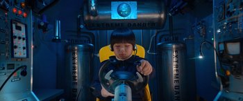 Movie still from “Barb and Star Go to Vista Del Mar” (2021), directed by Josh Greenbaum – A young girl sitting in front of a fire hydrant; Close Up shot, High angle