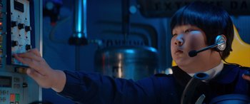 Movie still from “Barb and Star Go to Vista Del Mar” (2021), directed by Josh Greenbaum – A man in a blue jacket standing in front of an oven; Close Up shot, Low angle