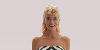 Movie still from “Barbie” (2023), directed by Greta Gerwig – A woman with blonde hair wearing a white and black striped dress; Medium shot, Low angle