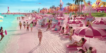 Movie still from “Barbie” (2023), directed by Greta Gerwig – A group of people sitting on the beach with pink umbrellas; Extreme Wide shot, High angle
