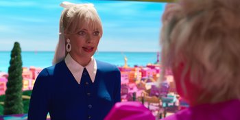 Movie still from “Barbie” (2023), directed by Greta Gerwig – A woman in a blue dress is looking in the mirror; Medium shot, Over the shoulder angle