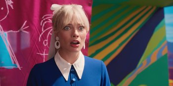 Movie still from “Barbie” (2023), directed by Greta Gerwig – A woman with blonde hair wearing a blue dress; Close Up shot, Over the shoulder angle