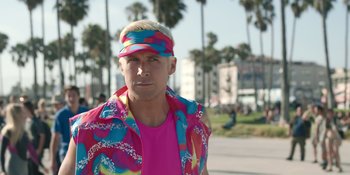 Movie still from “Barbie” (2023), directed by Greta Gerwig – A man in a pink shirt and a pink and blue hat; Medium shot, Over the shoulder angle