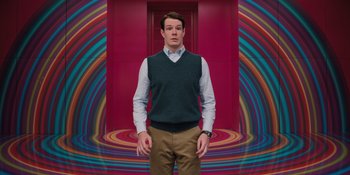 Movie still from “Barbie” (2023), directed by Greta Gerwig – A man standing in front of a colorful background; Medium shot, Low angle
