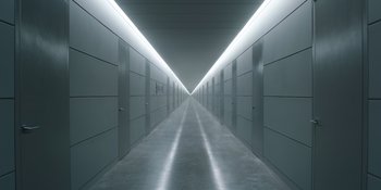 Movie still from “Barbie” (2023), directed by Greta Gerwig – A long hallway lined with white doors and walls; Extreme Wide shot, High angle