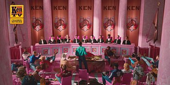 Movie still from “Barbie” (2023), directed by Greta Gerwig – A group of people sitting in a room with pink walls; Extreme Wide shot, High angle