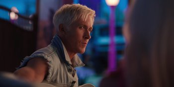 Movie still from “Barbie” (2023), directed by Greta Gerwig – A person holding a guitar; Close Up shot, Over the shoulder angle