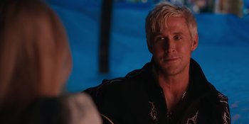 Movie still from “Barbie” (2023), directed by Greta Gerwig – A person sitting in front of a camera; Close Up shot, Over the shoulder angle