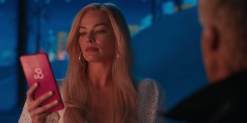 Movie still from “Barbie” (2023), directed by Greta Gerwig – A beautiful blonde woman with long hair wearing a white dress; Close Up shot, Over the shoulder angle