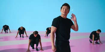 Movie still from “Barbie” (2023), directed by Greta Gerwig – A man standing in front of two other men on the ground; Medium shot, Low angle