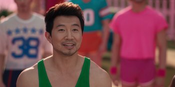 Movie still from “Barbie” (2023), directed by Greta Gerwig – A person wearing a green shirt; Close Up shot, Over the shoulder angle