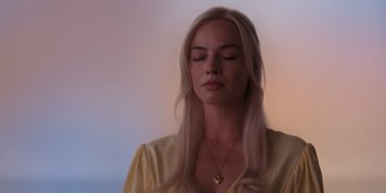 Movie still from “Barbie” (2023), directed by Greta Gerwig – A woman with long blonde hair wearing a yellow shirt; Close Up shot, Low angle