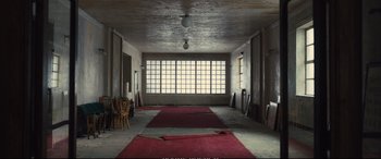Movie still from “Empire of Light” (2022), directed by Sam Mendes – A room that has a red carpet in the middle of it; Extreme Wide shot, High angle
