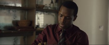 Movie still from “Empire of Light” (2022), directed by Sam Mendes – A man wearing a red shirt and a striped tie; Close Up shot, Over the shoulder angle