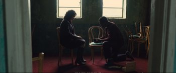 Movie still from “Empire of Light” (2022), directed by Sam Mendes – A man and a woman sitting on a chair in front of a window; Wide shot, High angle